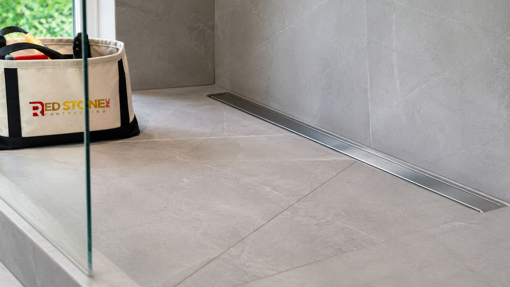Close-up of large format porcelain tile and linear drain from a bathroom renovation in Brampton shower