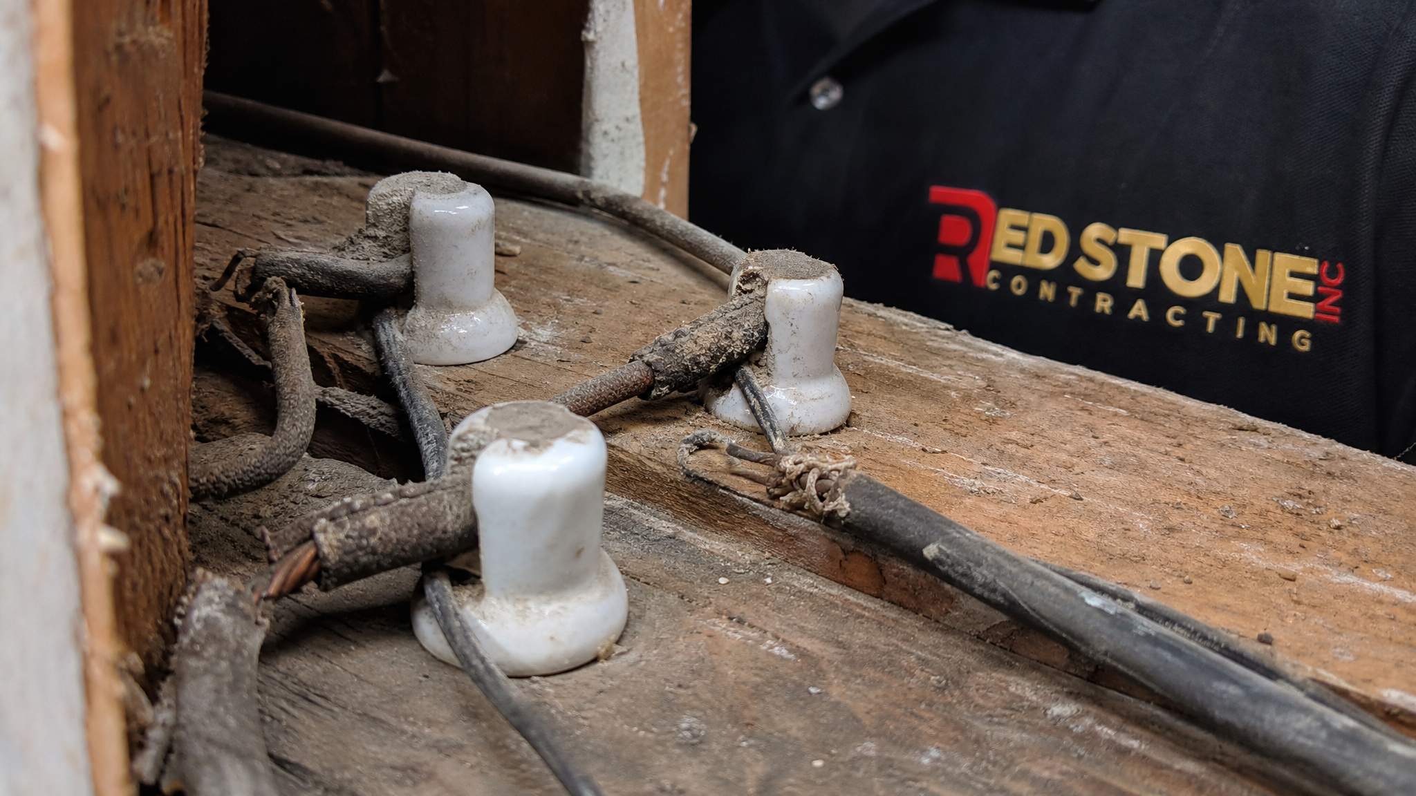 Close-up of original ceramic knob and tube wiring components removed from a wall cavity